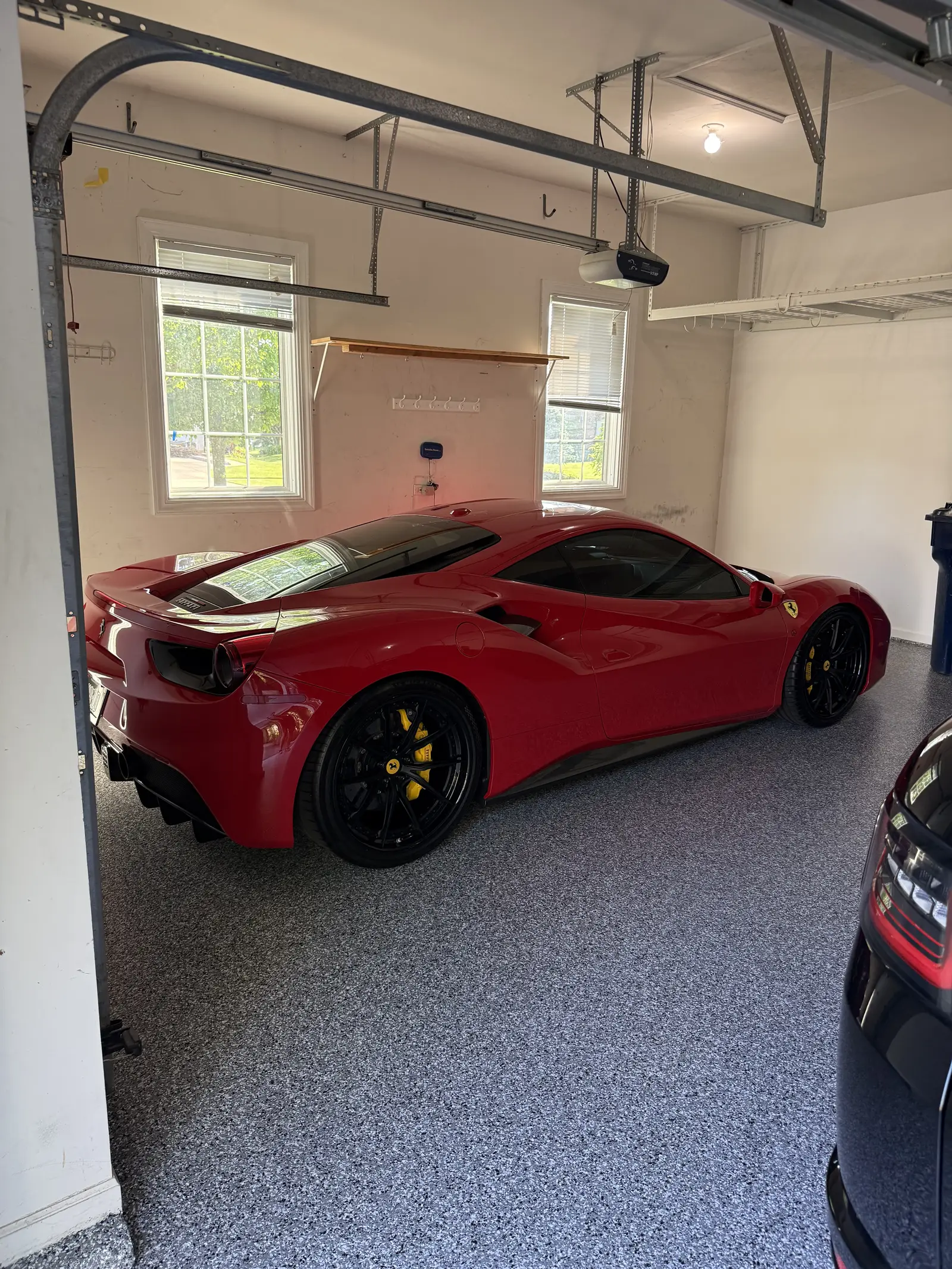 Red Ferrari parked on a flake coated garage floor