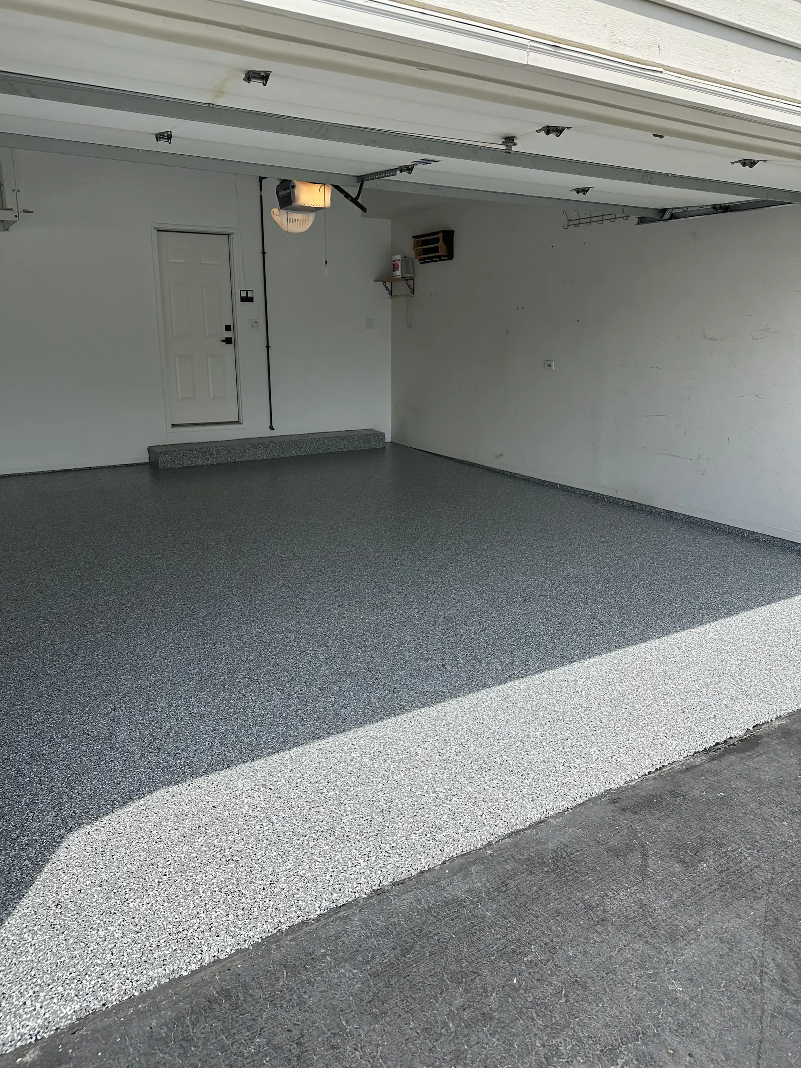 Grey flake coated floor across a finished two car garage