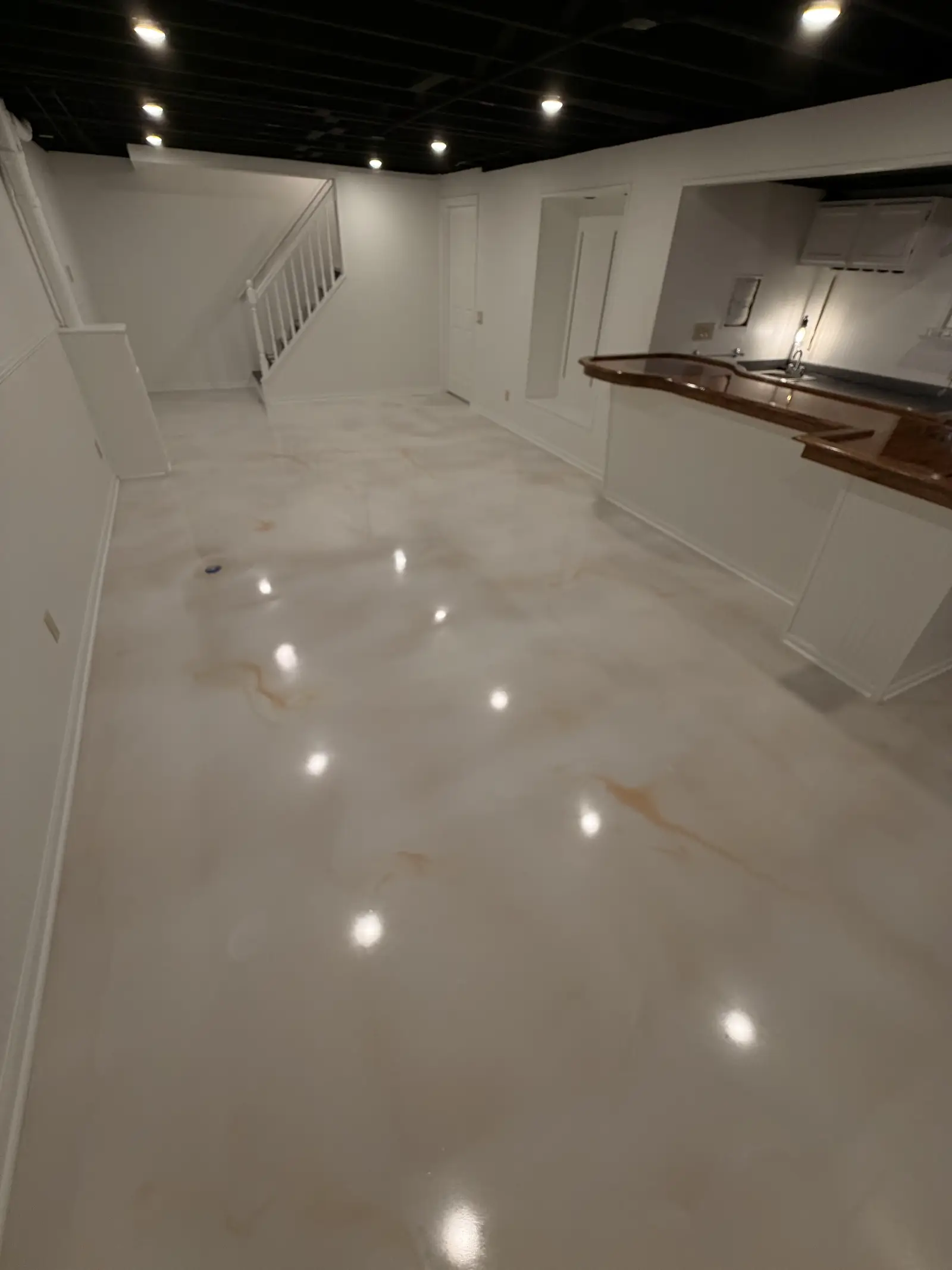 Pearl marble metallic floor running the length of a finished lower level