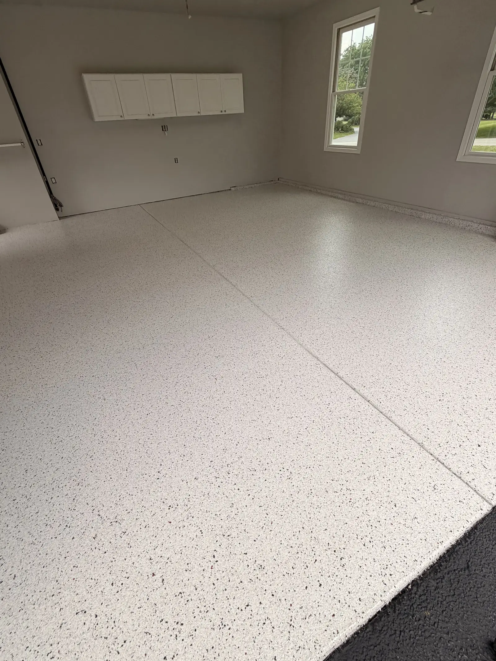 White flake coated garage floor in a bright finished garage